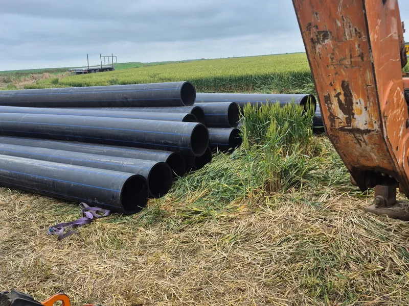 Alpasio Agro - stacked HDPE pipes and excavator